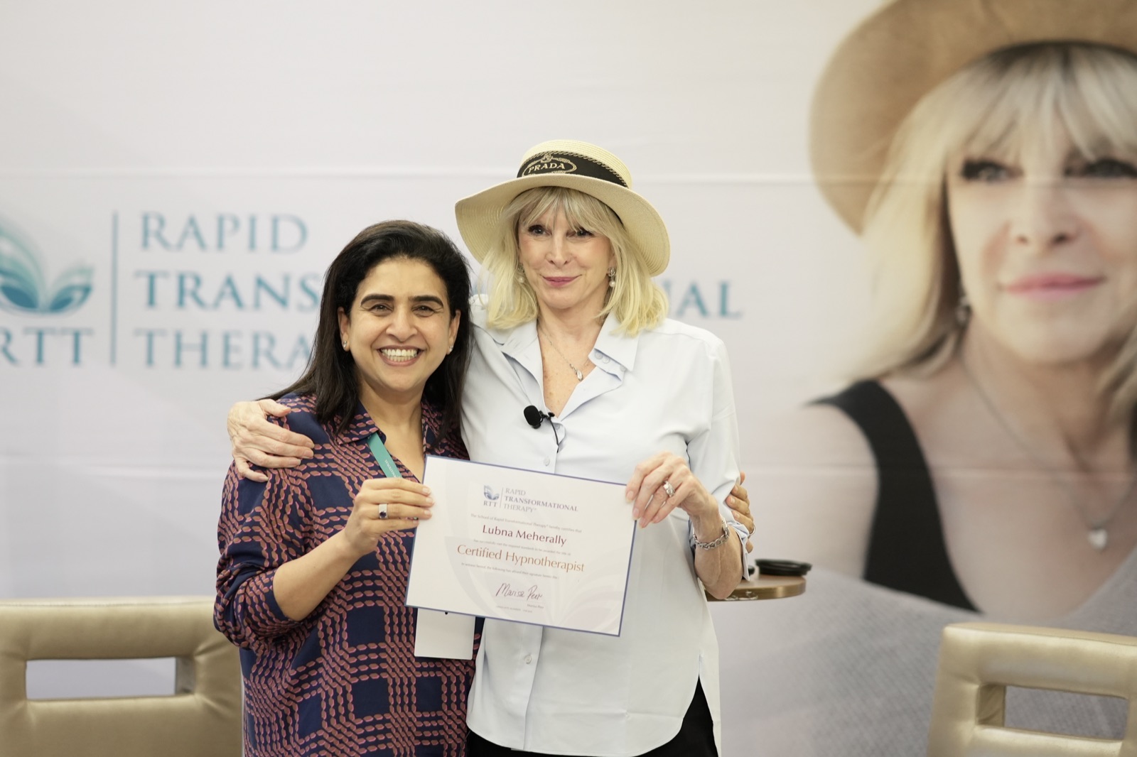 Lubna Meherally holding her certified hypnotherapist certificate with Marisa Peer