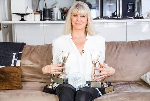 Marisa Peer, founder of Rapid Transformational Therapy, holding her awards